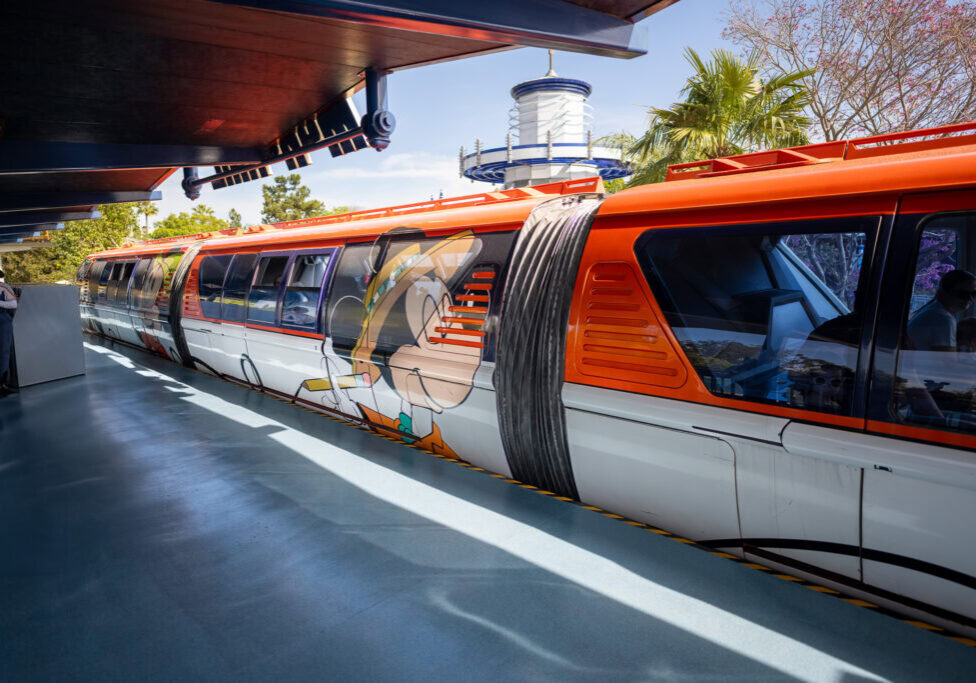 Monorraíl de Disneyland con Minnie Mouse en una obra de arte al estilo de Dapper Dan llegando a la estación de Tomorrowland.