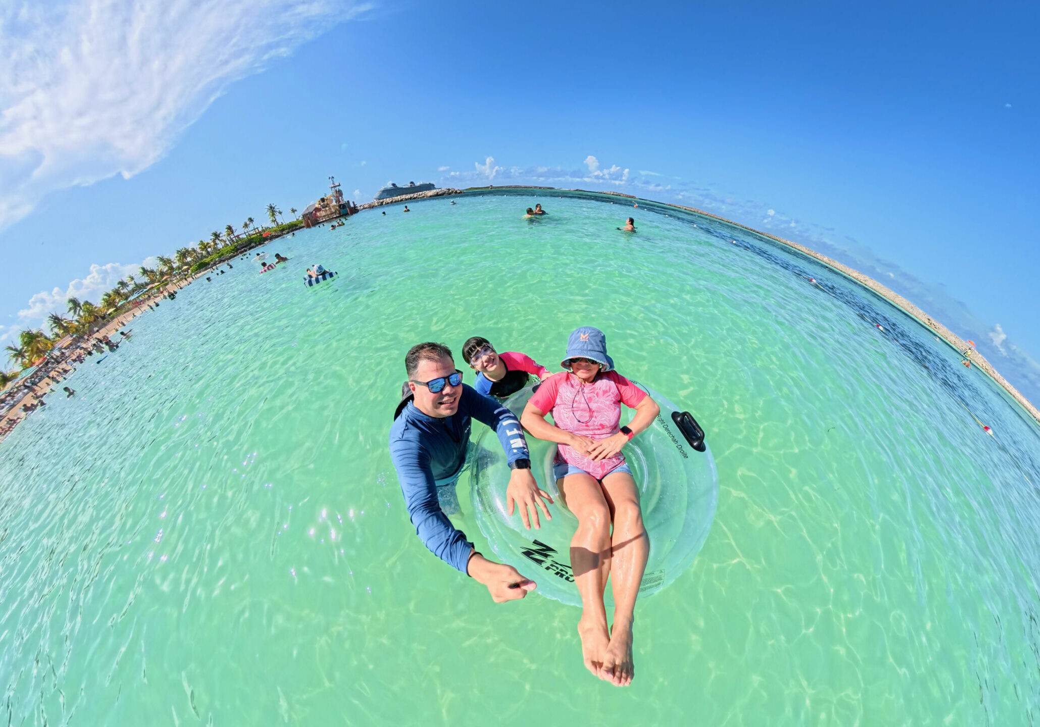 Family floating in the clear waters of Castaway Cay during a Disney Cruise Line beach day