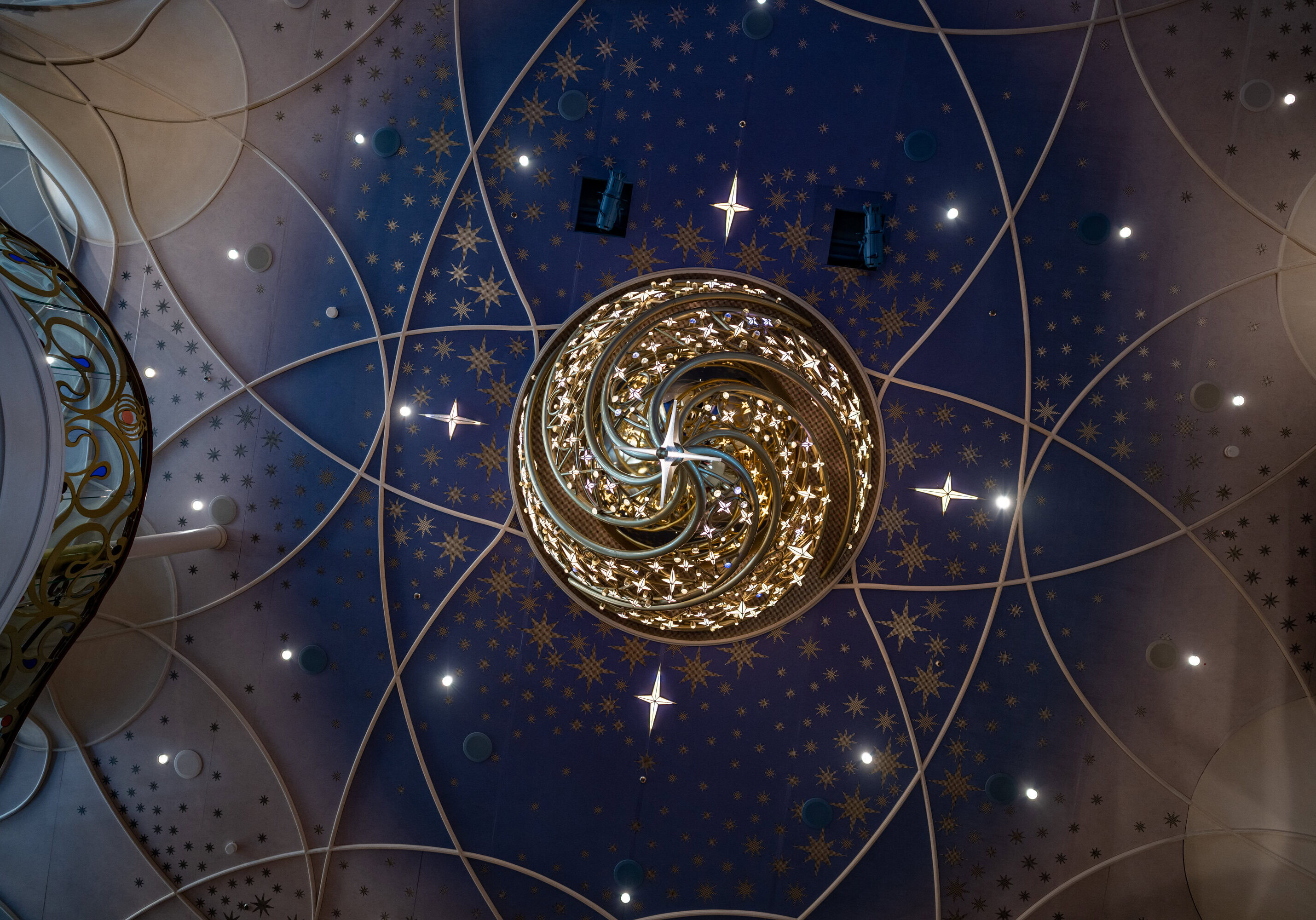 Candelabro ornamentado y estrellas en el techo dentro del gran salón Disney Wish