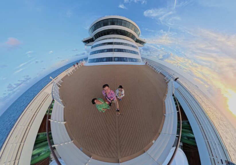 Family walking on the top deck of the Disney Wish at sunset during Nassau port day
