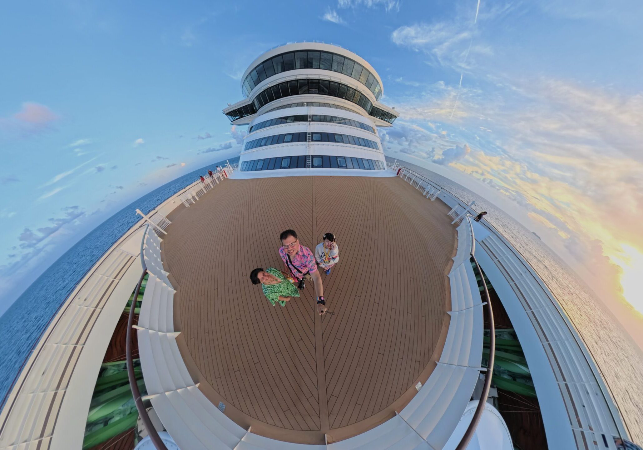 Family walking on the top deck of the Disney Wish at sunset during Nassau port day