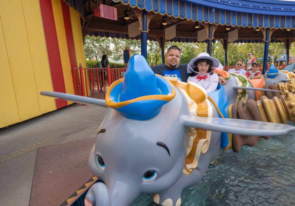 Family riding Dumbo ride at Magic Kingdom with daughter dressed as Mary Poppins.