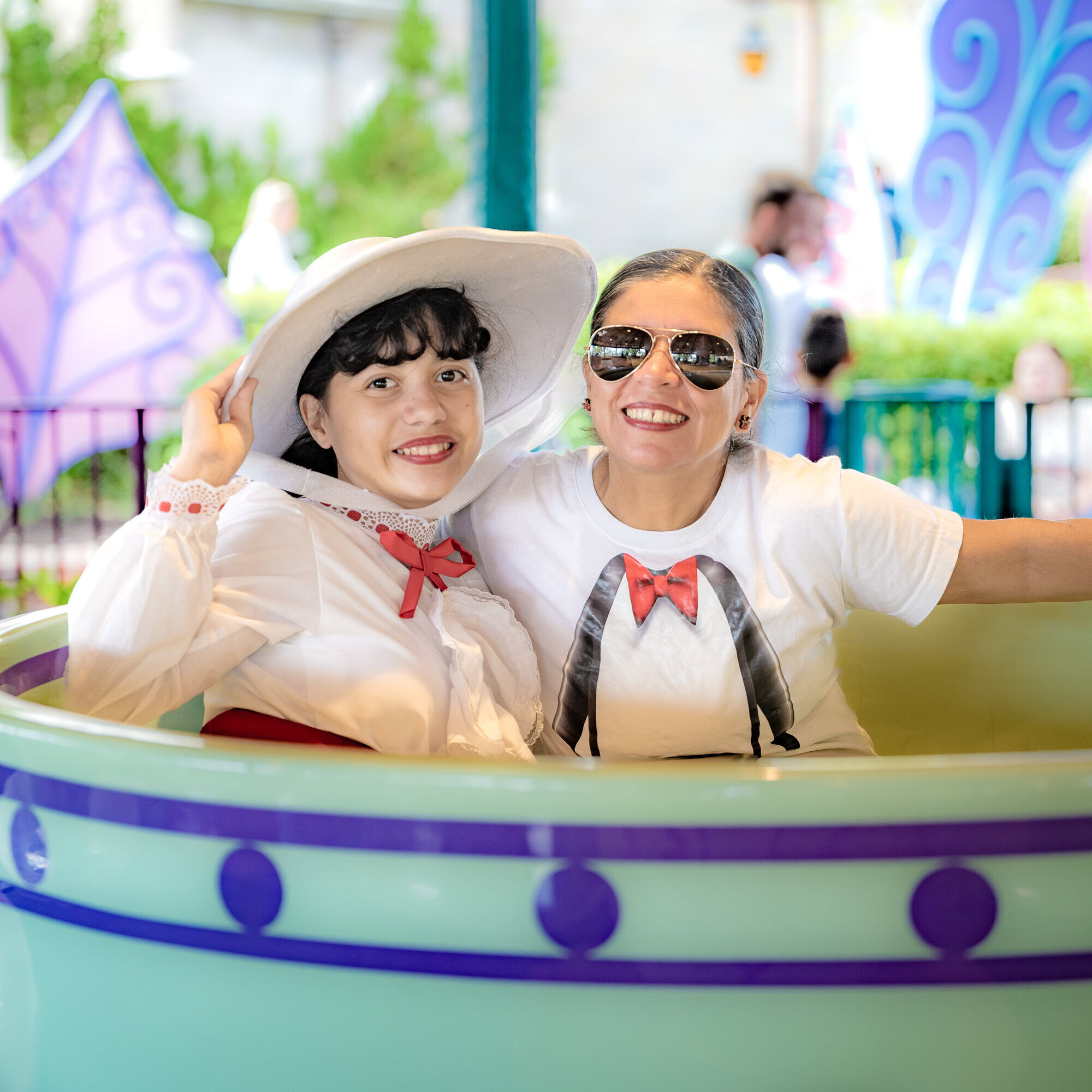 Lucy Feliciano and Daniela dressed as Mary Poppins riding the teacups at Magic Kingdom.