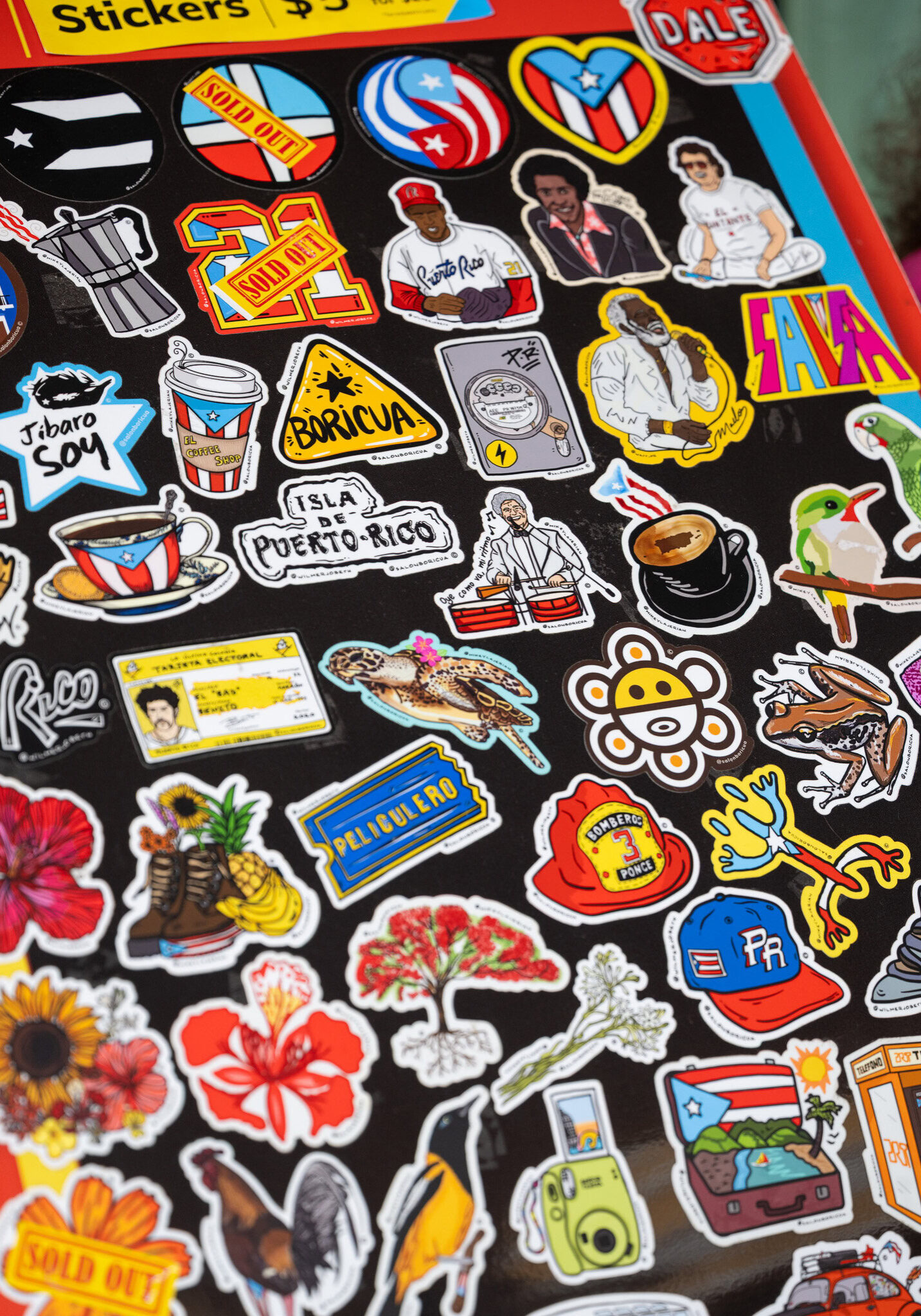 Sticker sheet, including flags, coffee cups, tropical flowers, and coquí
