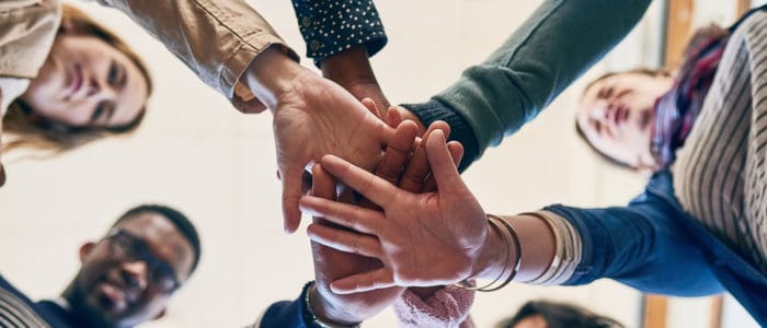 مجموعة من الناس يمسكون بأيديهم في دائرة.