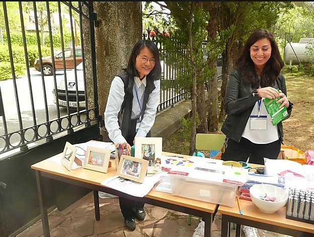 Paediatric palliative care Madrid Two smiling women from CAPPI Fundación porqueViven attend a table with photos and materials on paediatric palliative care. CAPPI Porque Viven Foundation