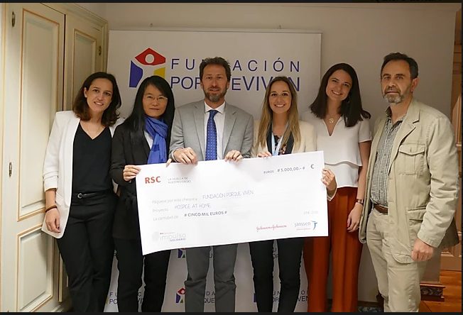 Paediatric palliative care Madrid Six people smile as they hand over a symbolic cheque in front of the logo of the CAPPI Foundation becauseThey live in Madrid. CAPPI Porque Viven Foundation