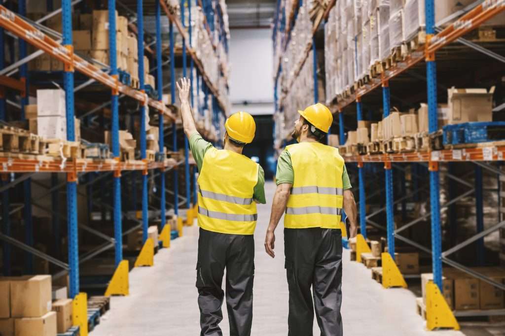 Dois trabalhadores, um faz, apontando para novos