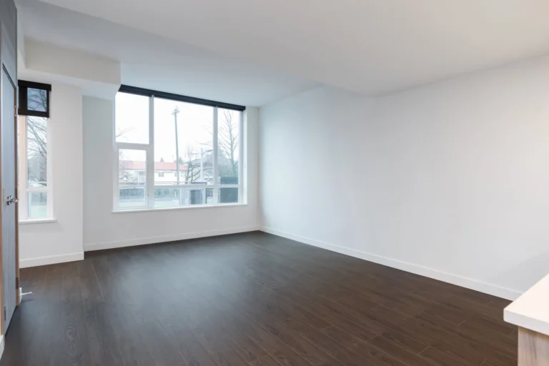 Une pièce vide avec du parquet et une fenêtre.