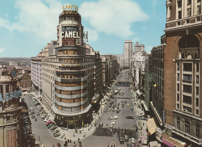 Gran Vía em Madrid com o Edifício Carrión (Capitólio) e o letreiro publicitário de cigarros Camel no topo, um exemplo de identidade gráfica urbana.
