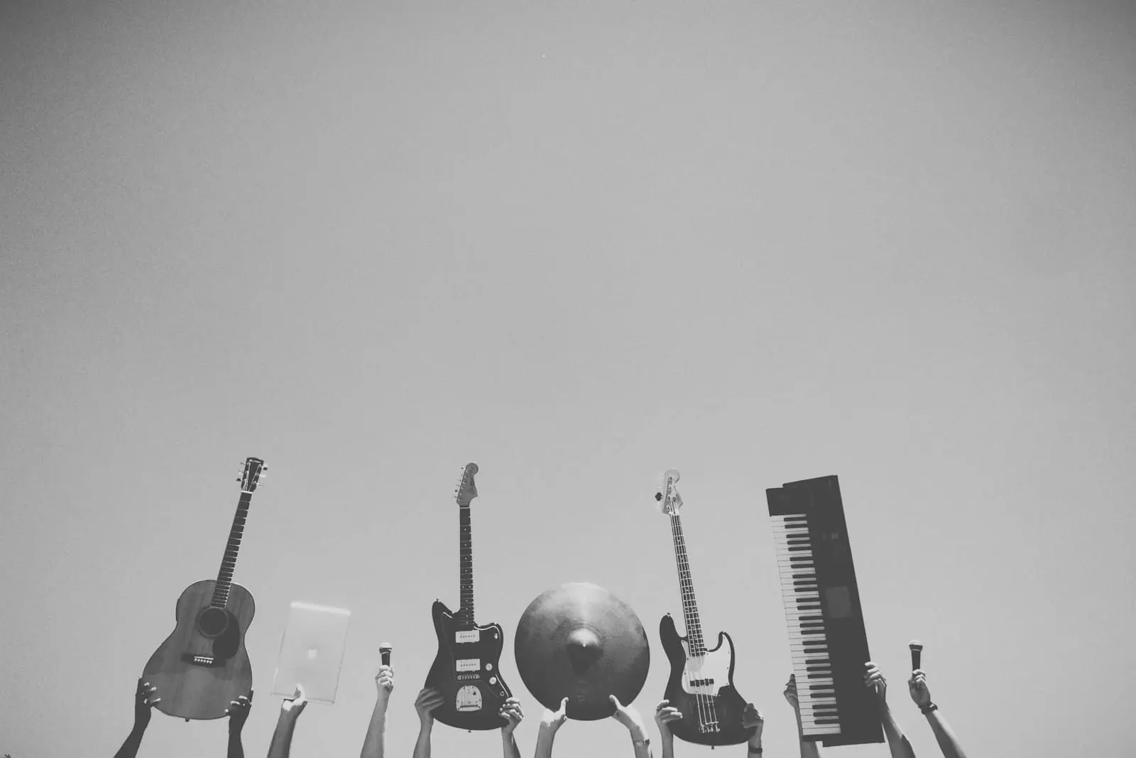 Foto en escala de grises de personas sosteniendo una variedad de instrumentos musicales