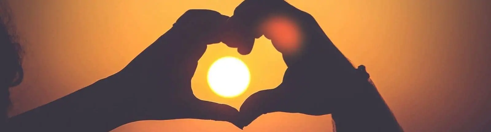 silueta de las manos de la persona formando corazón