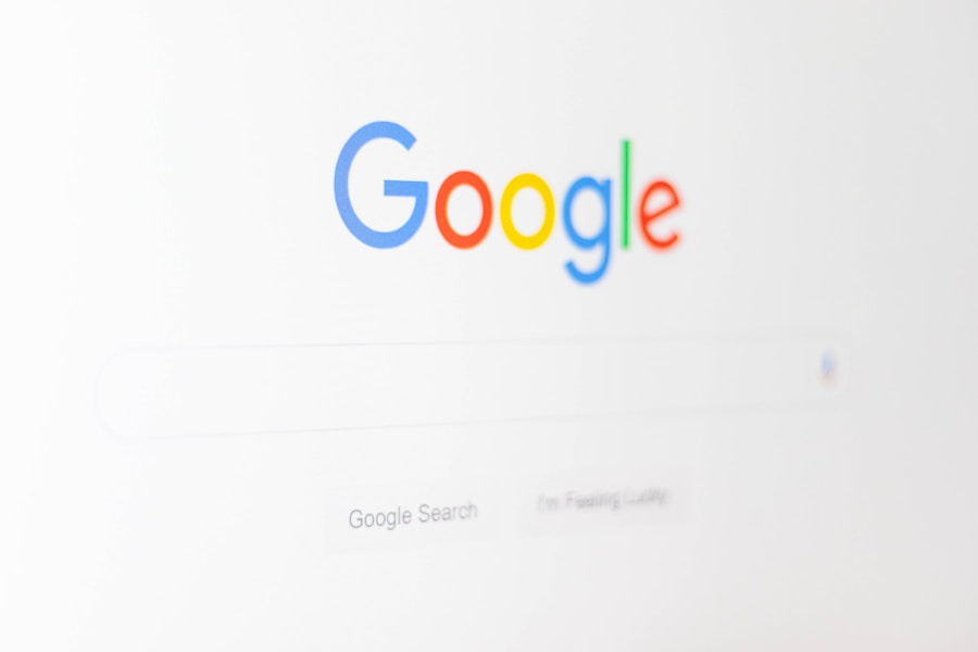 パソコン画面に表示されたGoogleホームページのクローズアップ。 空白の検索バーの上にGoogleロゴが表示されています。 背景はほぼ白で、ミニマルなデザインです。.