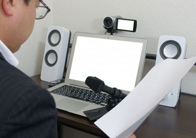 Man taking a photo with a laptop