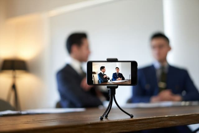 スマートフォンで男性2人を撮影する