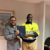 Eric Dulong remettant un certificat de fin d’études à un participant lors d’une cérémonie de développement du leadership