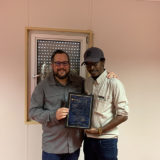 Eric Dulong remettant un certificat de fin d’études à un participant lors d’une cérémonie de développement du leadership