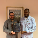 Eric Dulong remettant un certificat de fin d’études à un participant lors d’une cérémonie de développement du leadership