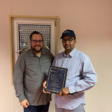 Eric Dulong remettant un certificat de fin d’études à un participant lors d’une cérémonie de développement du leadership