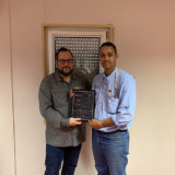 Eric Dulong remettant un certificat de fin d’études à un participant lors d’une cérémonie de développement du leadership