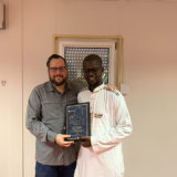 Eric Dulong remettant un certificat de fin d’études à un participant lors d’une cérémonie de développement du leadership