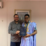 Eric Dulong remettant un certificat de fin d’études à un participant lors d’une cérémonie de développement du leadership