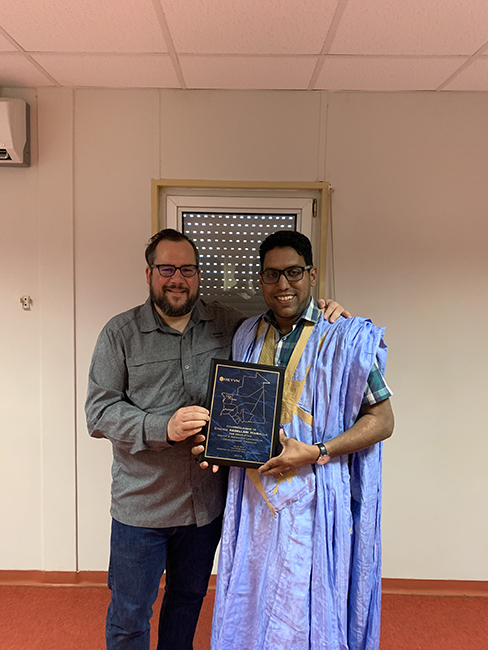 Eric Dulong remettant un certificat de fin d’études à un participant lors d’une cérémonie de développement du leadership