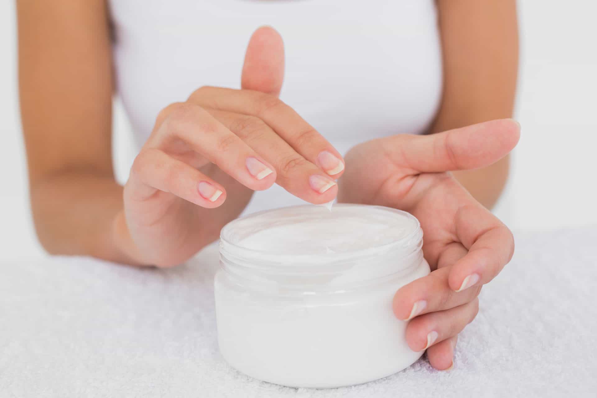 close-up-mid-section-of-woman-applying-cream-over-PJ88FD9.jpg