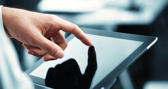 A hand points to a tablet displaying applications.