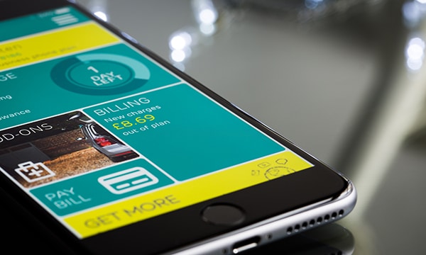 A mobile phone displays a yellow and green app.