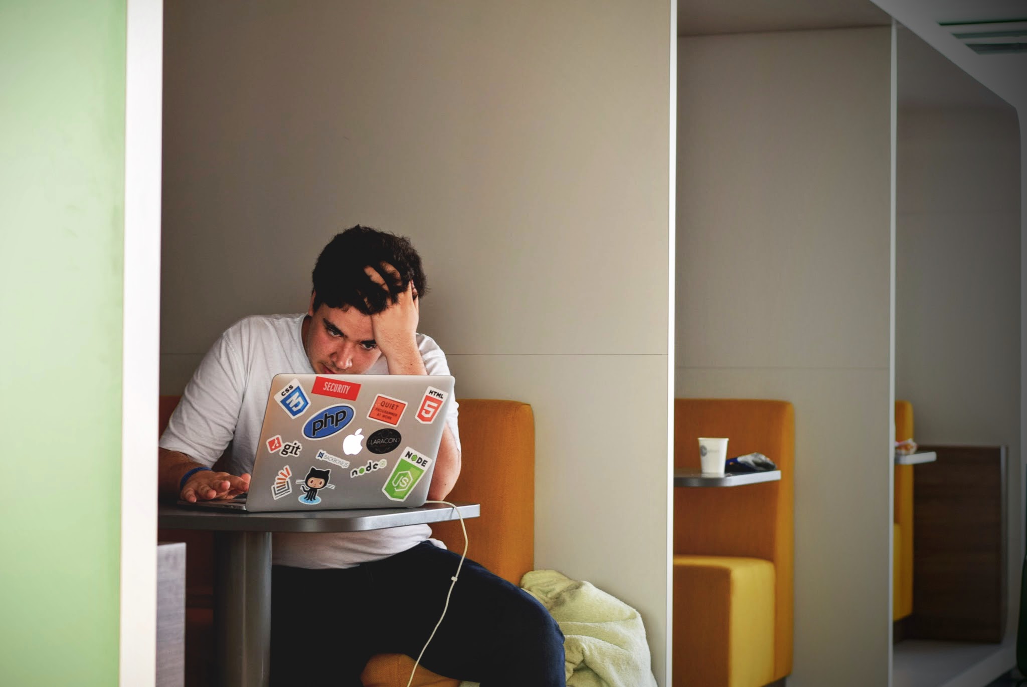 A man sitting at a table with a laptop.