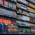 The organized aisles of a grocery store are full of different types of drinks.