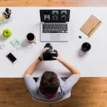A woman using Imagify to optimize images on her WordPress site while working on a laptop at a table.