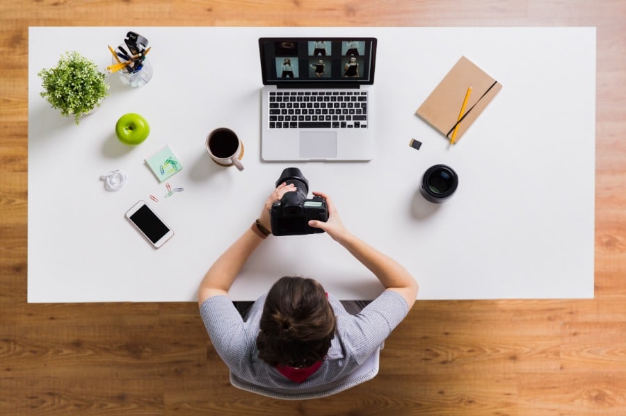 A woman using Imagify to optimize images on her WordPress site while working on a laptop at a table.