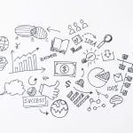 A doodle of business icons on a sheet of paper illustrating infographics and tools.