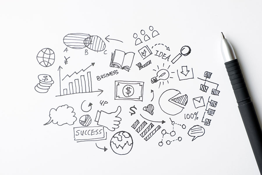 A doodle of business icons on a sheet of paper illustrating infographics and tools.