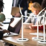 A group of people sitting around a table imprinted with wind turbines.