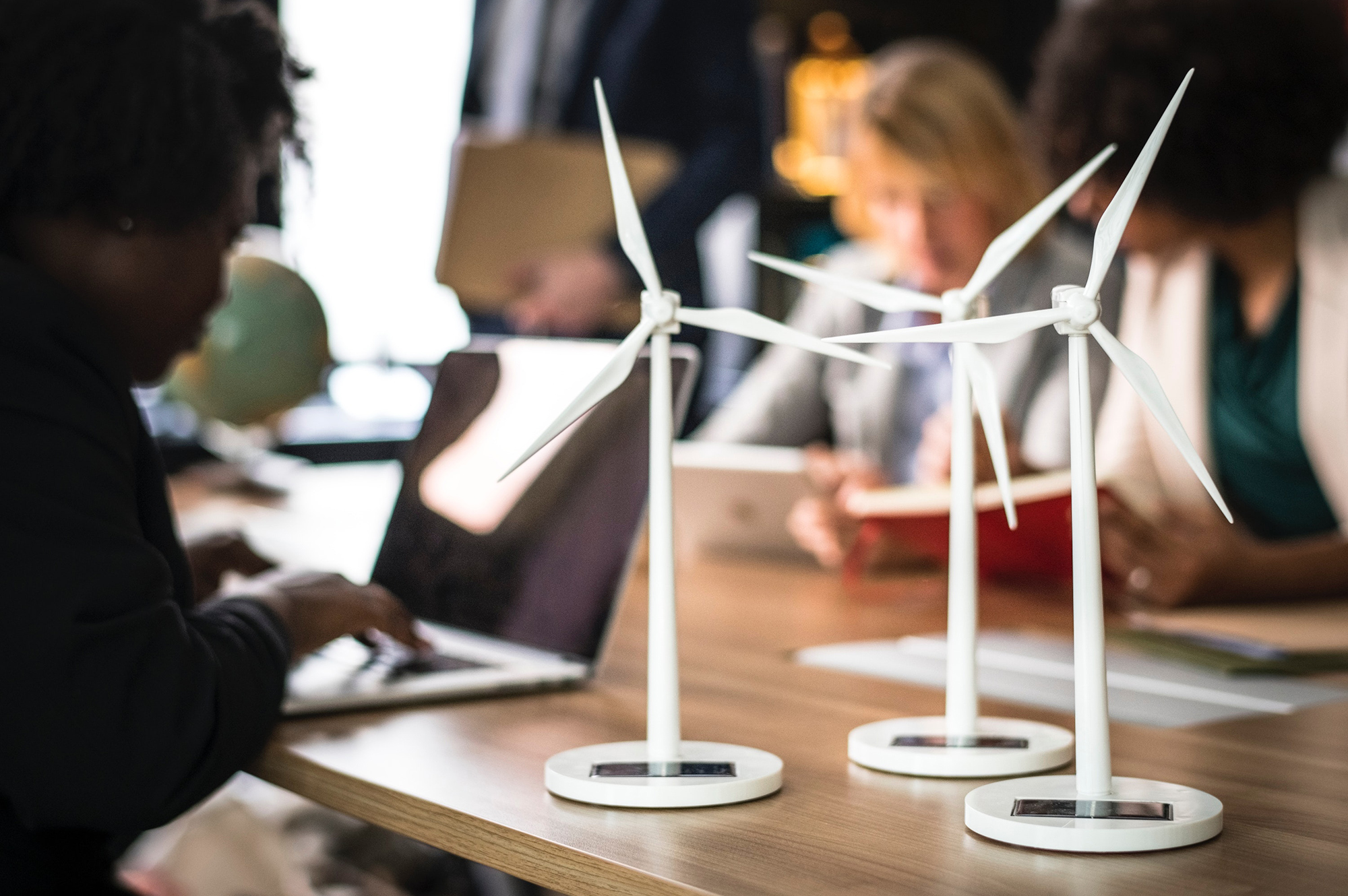 A group of people sitting around a table imprinted with wind turbines.