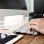 A man types on a keyboard to format images in WordPress using webp.