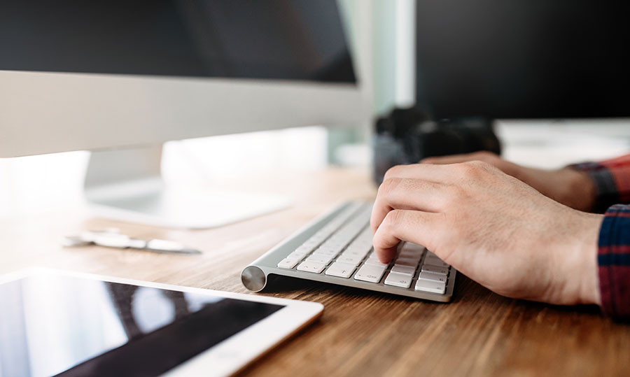 A man types on a keyboard to format images in WordPress using webp.