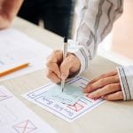 A person creating a UX design sketch on paper.