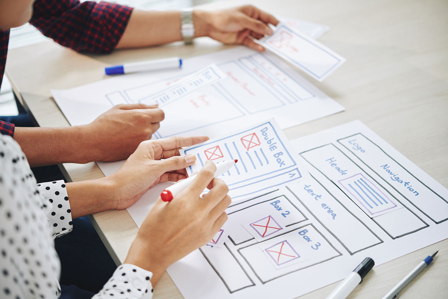 Two people sitting at a table with paper and pencils while discussing SEO strategies.