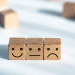 Three wooden cubes with smileys for sale on a Woocommerce platform.