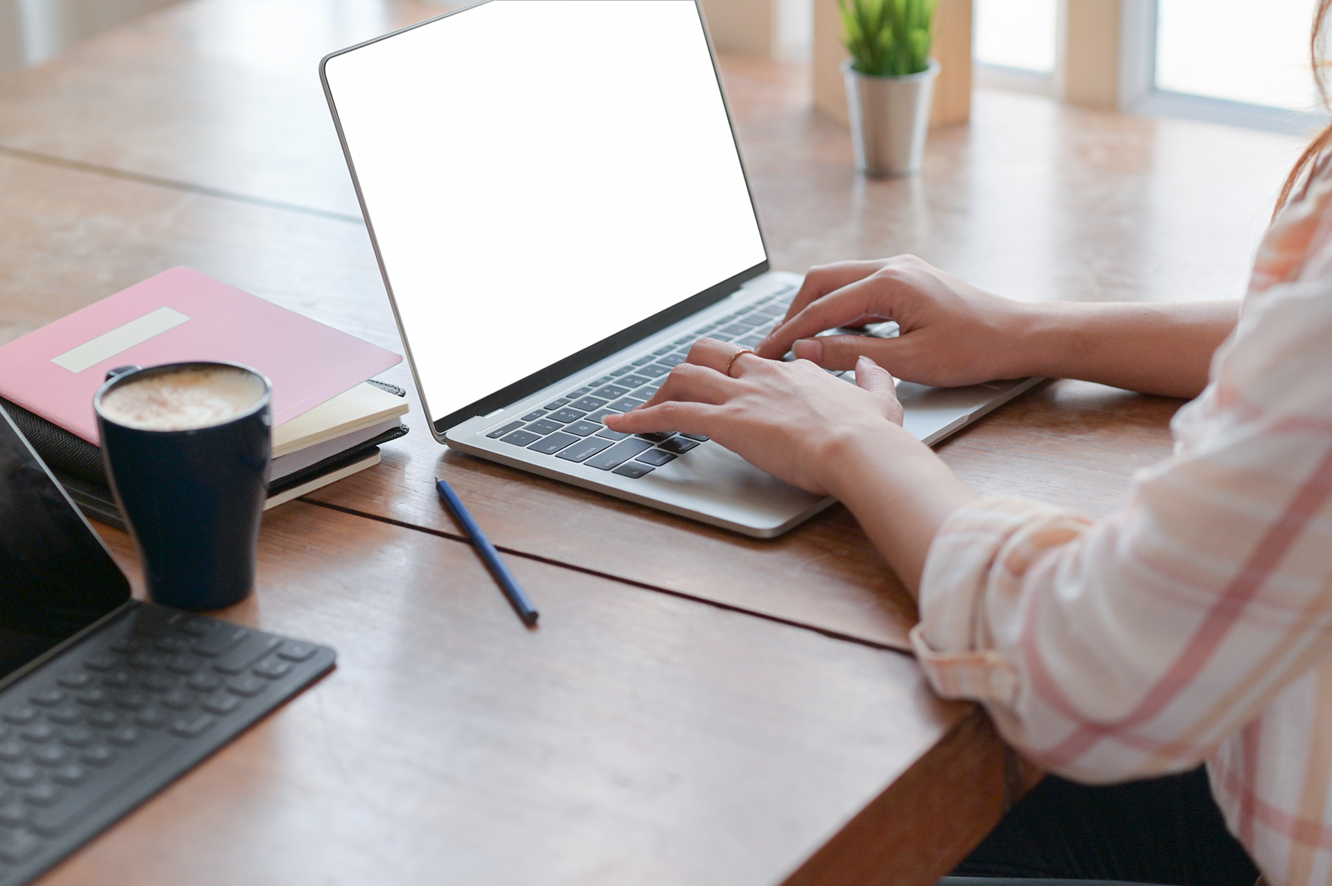 A woman typing on a laptop at a desk while using Convertio.co.